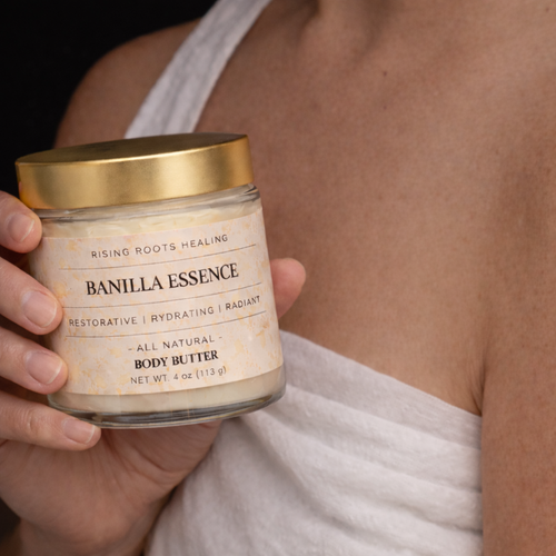 Person holding a jar of 'Banilla Essence' body butter with a gold lid.